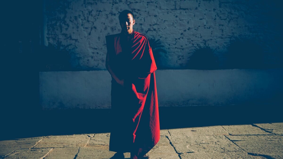 Monk in shadow at sunset in the Paro Dzong. Photo via Flickr by Craig Allen. CC BY-NC-ND 2.0