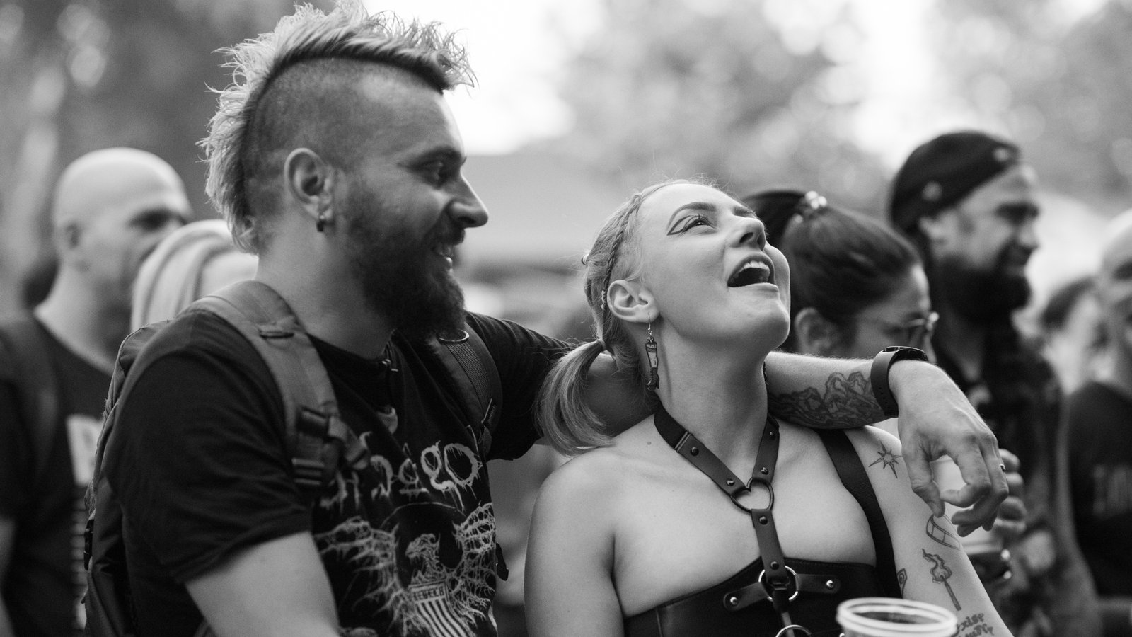 Un homme et une femme dans la foule au concert d'Urban Grey au Hills of Rock 2025, partageant un moment de joie, souriants et chantant à tue-tête.