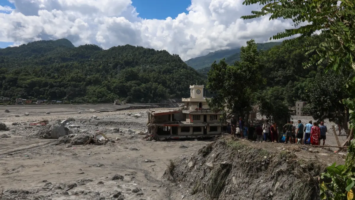 People look on at the mud in the aftermath of the flood. Photo by Suman Nepali of Nepali Times. Used with permission.